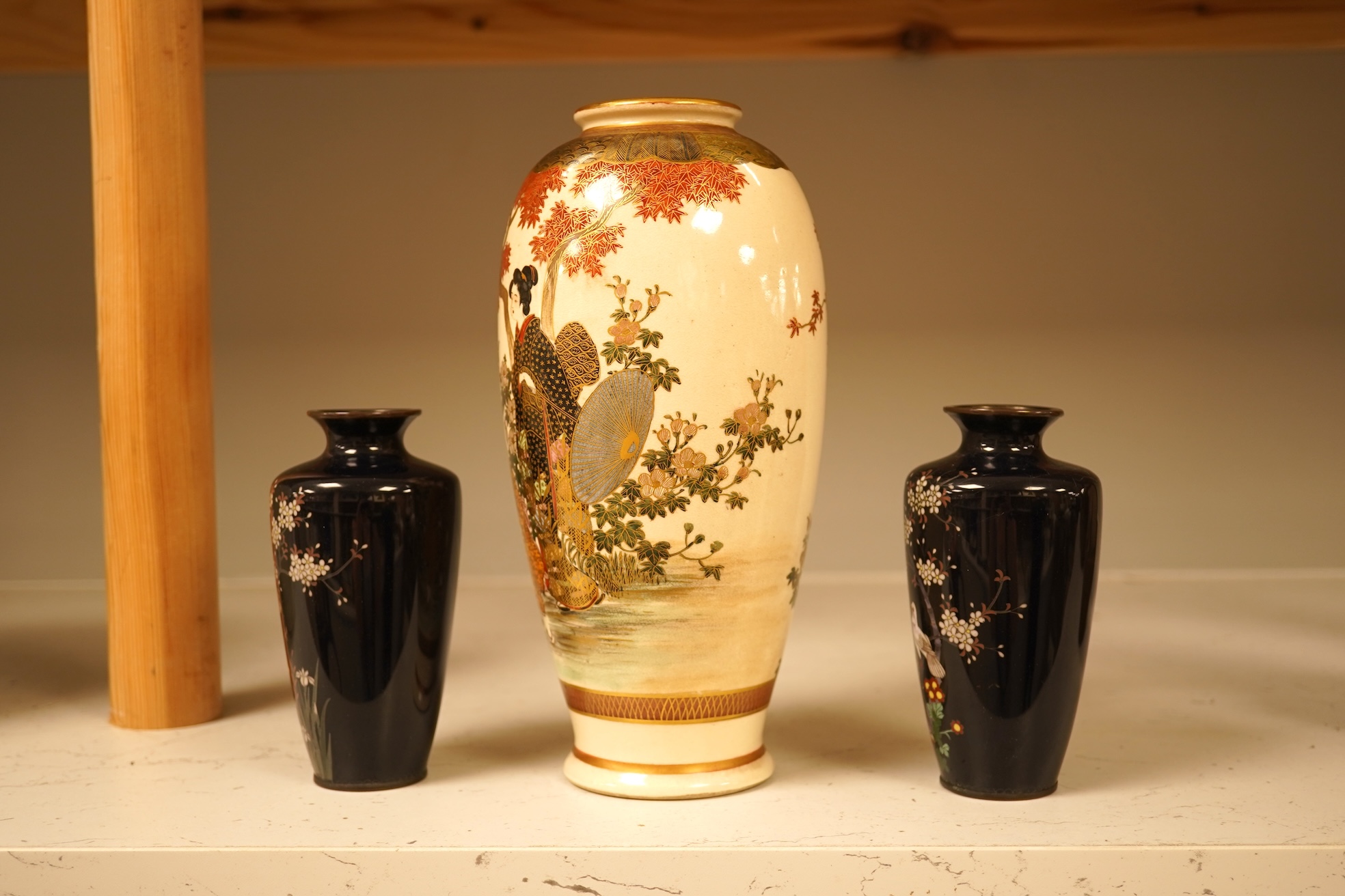 A Japanese figural satsuma vase and a pair of small black cloisonné enamel vases, Satsuma 21.5cm high